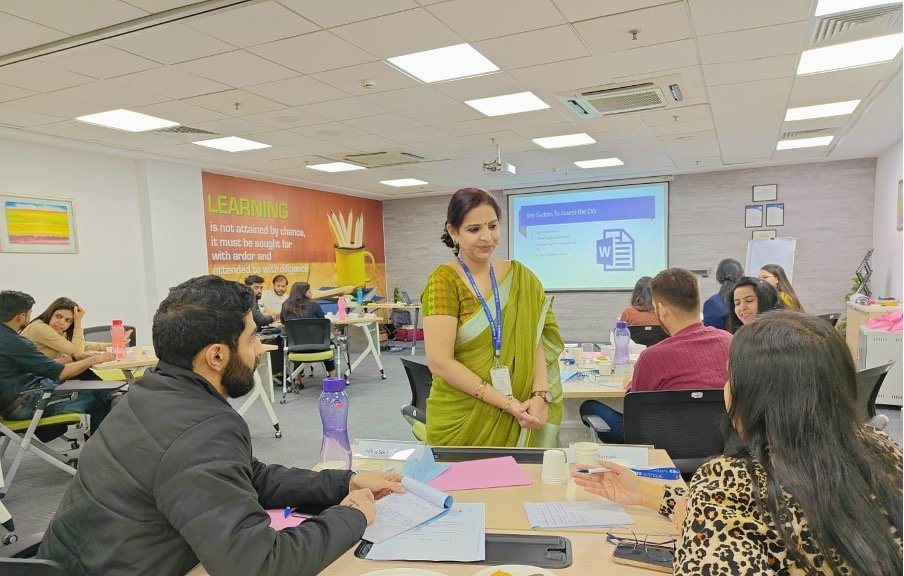 Facilitator leading a learning and capability development workshop with participants at tables